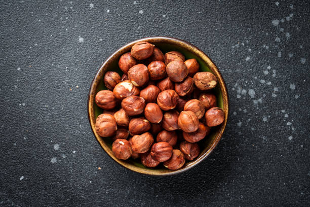 istock Hazelnuts in bowl at black background. 2037550659