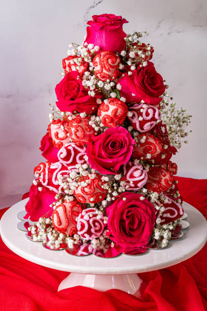 istock Rose tower with babys breath and decorated chocolate covered strawberries on a white cake stand 2037568510