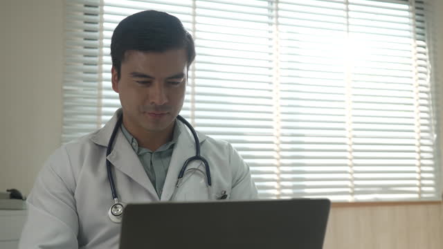 Doctor is working with laptop at hospital.