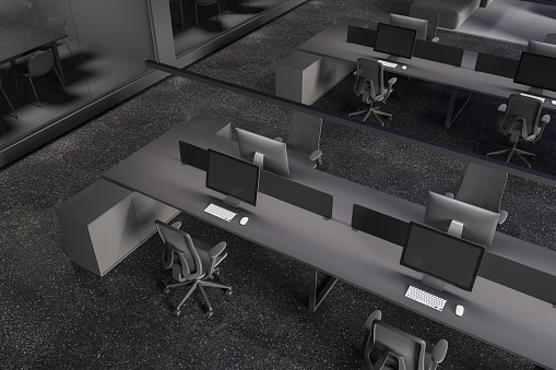 Top view of dark office interior with coworking corner, pc computers on shared desk and chairs in row. Glass minimalist meeting boxes with table and chairs. 3D rendering
