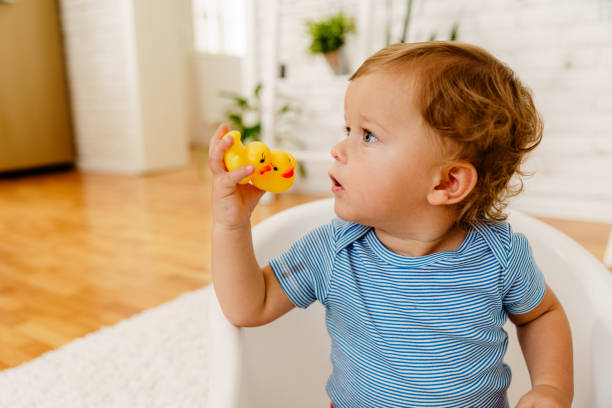 istock Toddler playing with  rubber duck toy at home 2037609510
