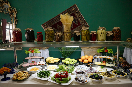A visually enticing buffet table showcases a diverse array of scrumptious foods, including international cuisines, meats, seafood, salads, desserts, and condiments.