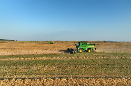 Combine harvester on Wheat harvesting in field. John Deere Combine harvester on Wheat planting. Wheat and corn. Farm field with Rye. Harvester on harvesting in field. Kazakhstan Alma-Ata, Aug 12, 2023
