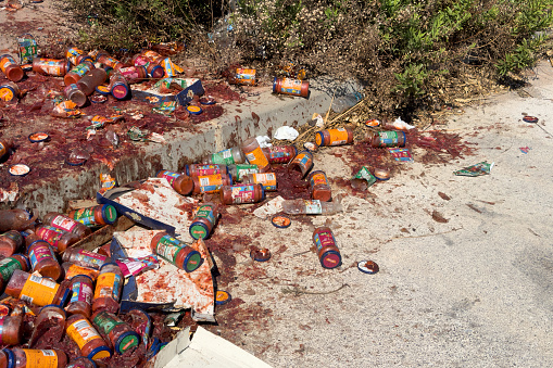 Trash food. Upcycled food on road. Rotten tomato paste in broken glass jars on asphalt. Food waste is problem to climate change. Tomatoes trash, Upcycle garbage. June 5, 2023, Spain, Sagunto