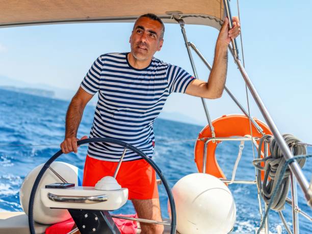 man is driving a sailboat and enjoying it. - yacht nautical vessel autopilot sailing imagens e fotografias de stock