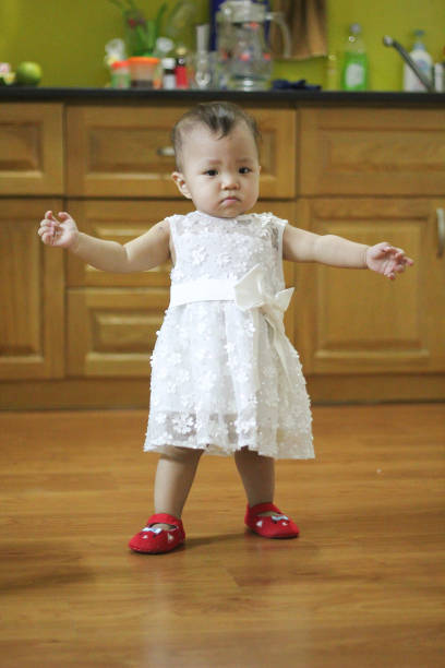 Clothing for newborn. A pair of cute baby pink shoes with a bow for girls on a white bed