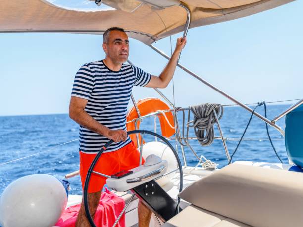 man is driving a sailboat and enjoying it. - yacht nautical vessel autopilot sailing imagens e fotografias de stock