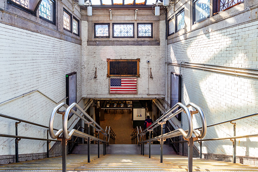 Boston, Massachusetts, USA - February 20, 2024: View down the stairs of the entrance to the Massachusetts Bay Transportation Authority's (MBTA) Park Street subway station at the corner of Park and Tremont Streets in downtown Boston. Opened in 1897, it is one of the oldest stations on the 