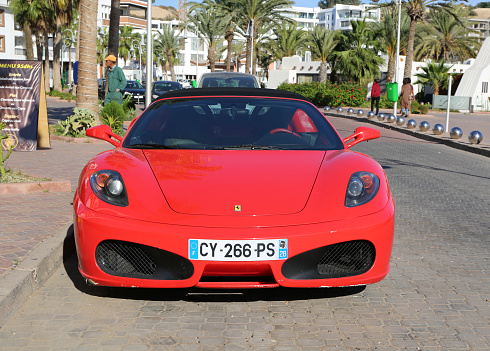 Agadir, Morocco-December 11,2015:Red Ferrari Luxury Car with French License Plate parked next to Agadir Marina