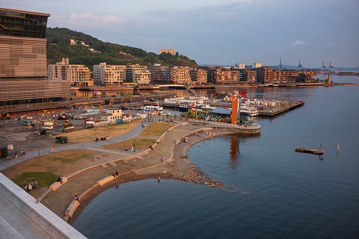 Oslo, Norway, June 20, 2023: Operastranda in Bjørvika is a large sandy beach right in the middle of Oslo, particularly suited for families, shown here from above the opera house at sunset.