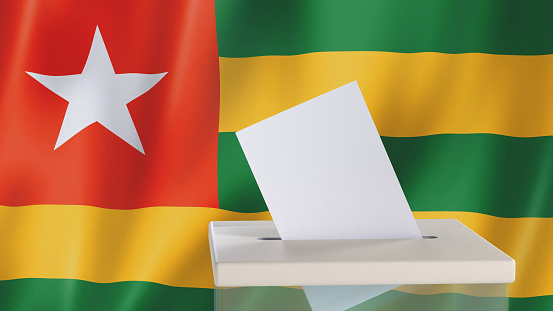 Blank ballot with space for text or logo is dropped into the ballot box against the background of the flag of Togo. Election concept. 3D rendering. Mock up