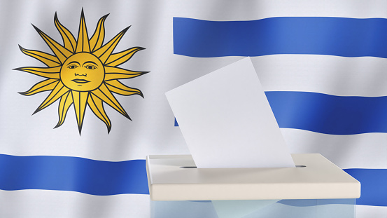 Blank ballot with space for text or logo is dropped into the ballot box against the background of the flag of Uruguay. Election concept. 3D rendering. Mock up