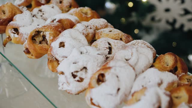 Beautiful confectionery sprinkled with powdered sugar. The treats are on the festive table
