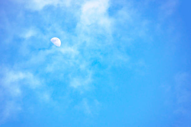moon in the daytime and white cloud floating in the sky.