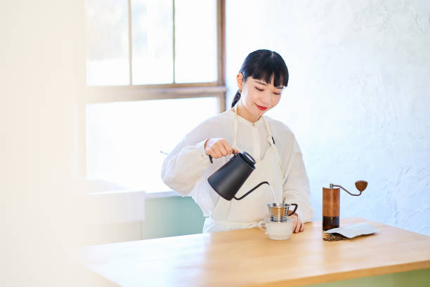 Young woman making coffee in the kitchen