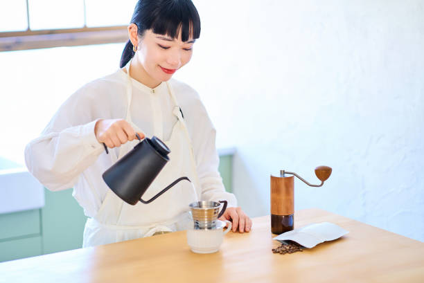 istock Young woman making coffee in the kitchen 2037860979
