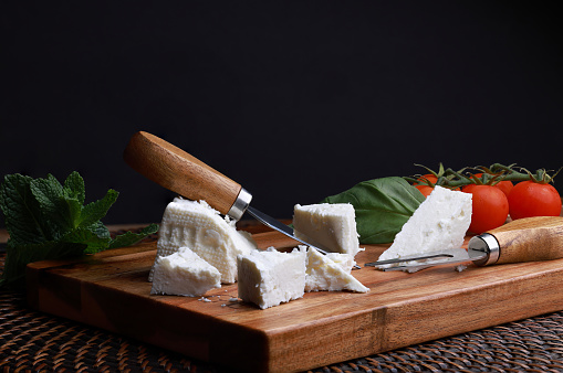 Delicious Telemea Cheese on mahogany Cheeseboard with black background