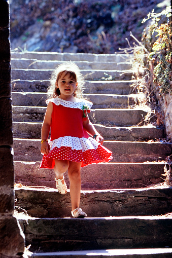 Young girl child goes down the stairs of the old village of Bourg sur Gironde on july 18-1995