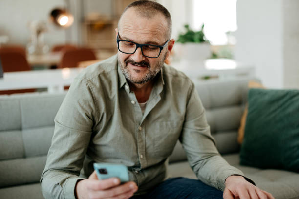 istock Man uses a mobile phone at home 2037900248