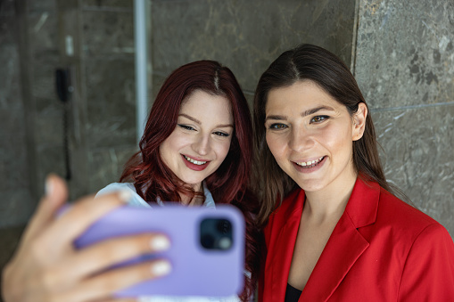 Young employees take selfies in the workplace .