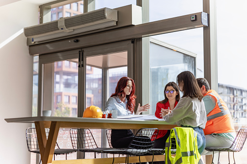 Positive Office Meeting: Manager and Creative Team Sitting and Meeting in a Modern and Bright Workspace Boardroom