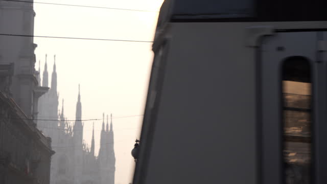 Milan tram passes by and behind it there is the Duomo Milano