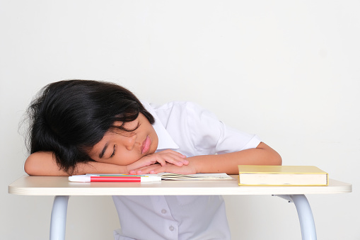 Kid student sleeping on school desk showing tiredness