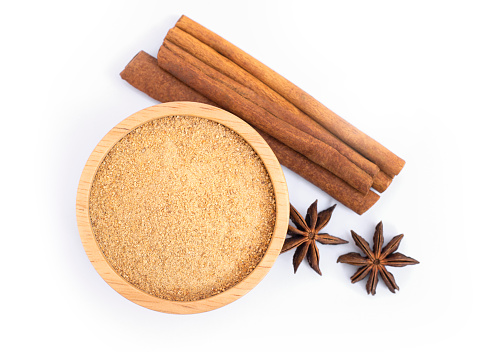 Cinnamon powder in wooden bowl and cinamon sticks with star anise isolated on white background. Natural herbal plant, spices seasoning concept. Top view. flat lay.