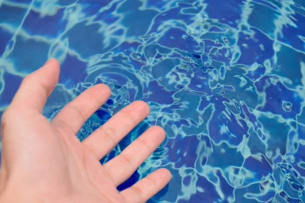 istock Hands touching the surface of the water until it forms waves with beautiful patterns close-up at outdoor swimming pool for concept of exercise and outdoor activities. 2037919180