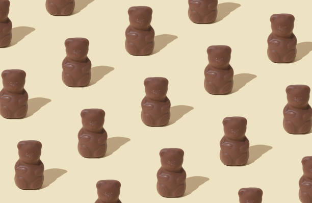istock Trendy pattern composition made with chocolate teddy bears on pastel cream background. Creative sweet food concept. Yummy chocolate teddy bear idea. Minimal style. Chocolate aesthetic. 2037924449
