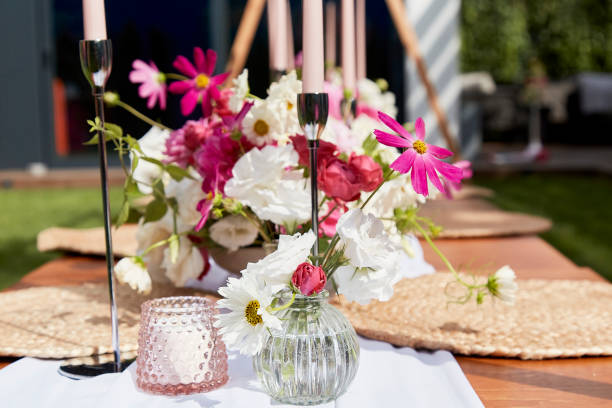 istock Romantic table arrangement with candles and flowers on festively adorned table. Decorating and special occasion planning concept 2037925057