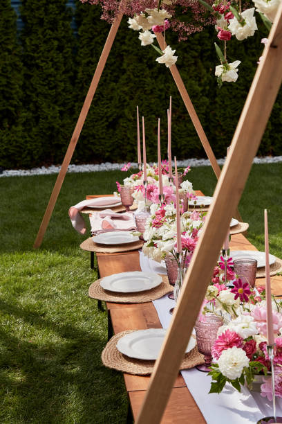 istock Long candles wit pink and white flowers on festive table. Visuals for event planning and design summer picnic party. Outdoor party. 2037931016