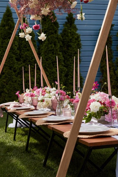 istock Elegant outdoor table setting with tall pink candles. Romantic dining experience, summer garden picnic. 2037931018