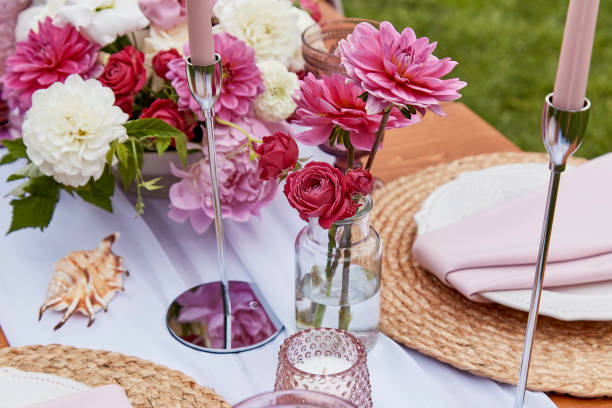 istock Picnic aesthetics table setting, flowers arrangement, shells. Cozy setup with flowers and candles 2037932102