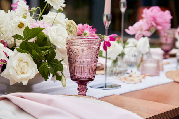 istock Outside aesthetic festive table setting among pink flowers arrangement, candles and shells decor 2037936486