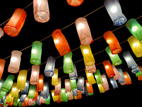 Floating lanterns or colorful lanterns for decorating festivals are made from colorful paper on a dark background.