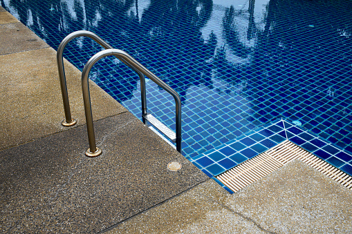 View of the swimming pool and swimming pool ladder decorated with gravel walkways in vintage tones.