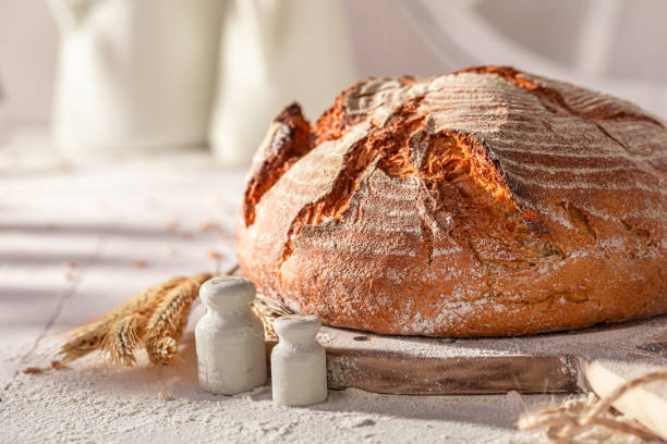 istock Crispy round loaf bread on wooden cutting board. 2037961806