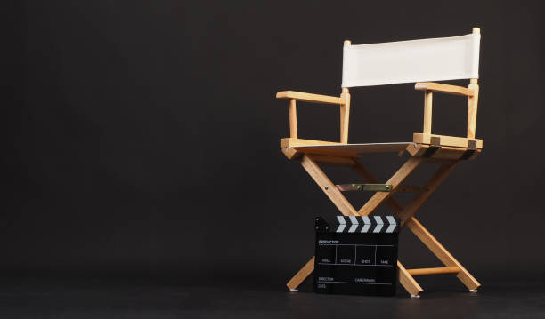 istock White director chair with clapper board on black background 2037983429