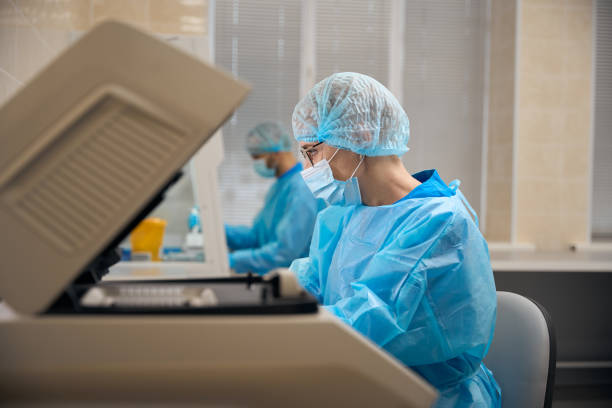 istock Female laboratory assistant works in a protective mask 2037985663