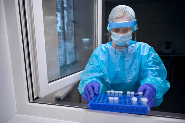 istock Female in protective equipment holds organizer with test tubes in her hands 2037985700