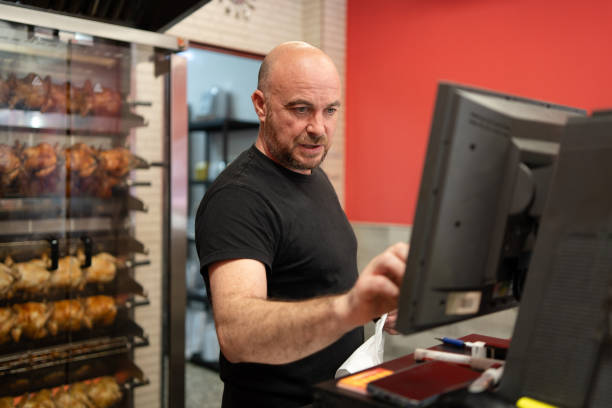 mann bereitet eine bestellung an der theke eines drehspießes vor - supermarket meat store manager stock-fotos und bilder