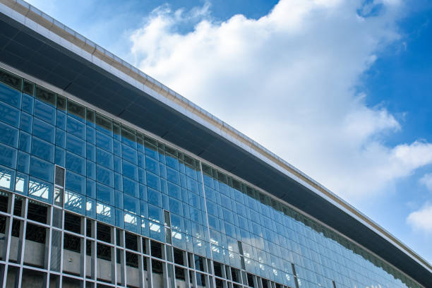 istock Modern architecture curved building with glass decorations and cool tones isolated against a bright blue sky background. Modern train station building in the capital. 2038003705