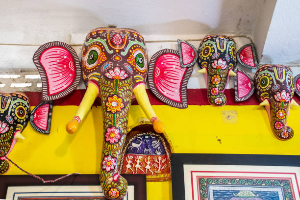 An Indian elephant, his own shadow and the mahout's, as seen on the wall in background.