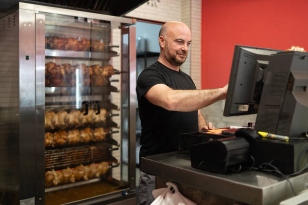 employee in rotisserie working at the checkout - supermarket meat store manager imagens e fotografias de stock