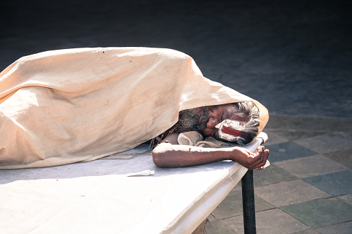 Jaipur, India - 2014, December 29 : An Indian holy man sleeping inside a Hindu temple on Choti Chaupar square in the city of Jaipur, also known as the Pink City in Rajasthan, India