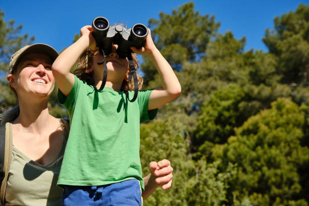 istock Mother teaching her little son to use binoculars in nature. 2038073369