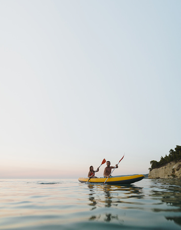 Photo of a couple paddling on the ocean.