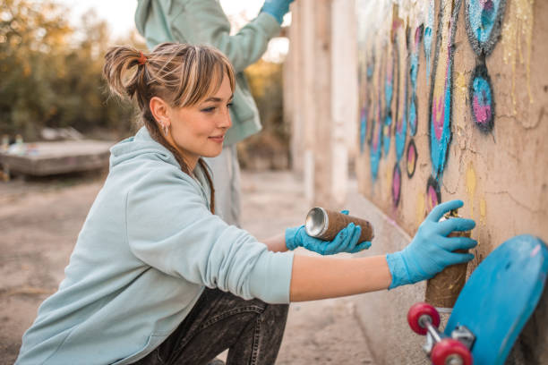 istock A smiling artist enjoys drawing graffiti with her friend 2038101489