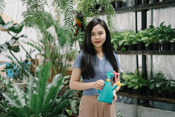 istock Asian beauty watering plants at home 2038102586